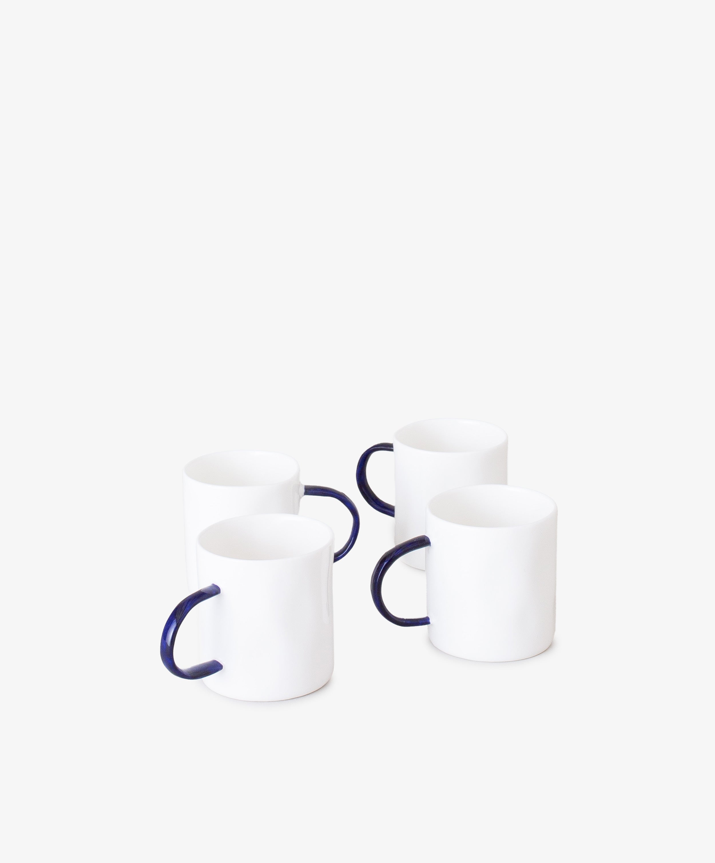 Grouping of four white china espresso cups with thin, rounded cobalt blue handles.