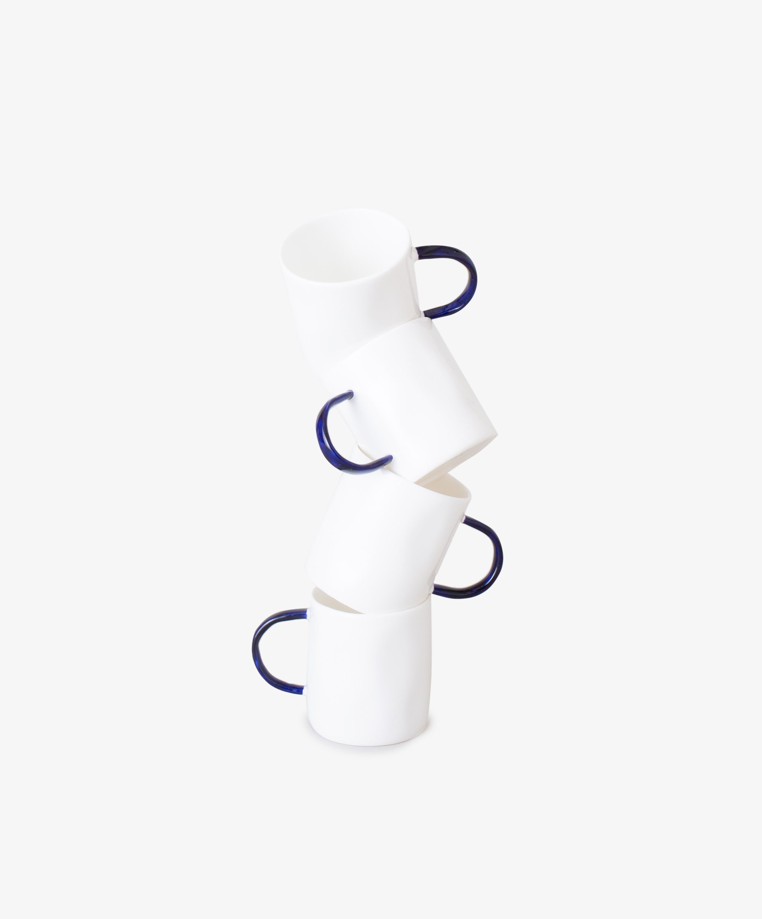 Stack of four white china espresso cups with bases askew.