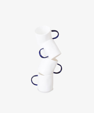 Stack of four white china espresso cups with bases askew.