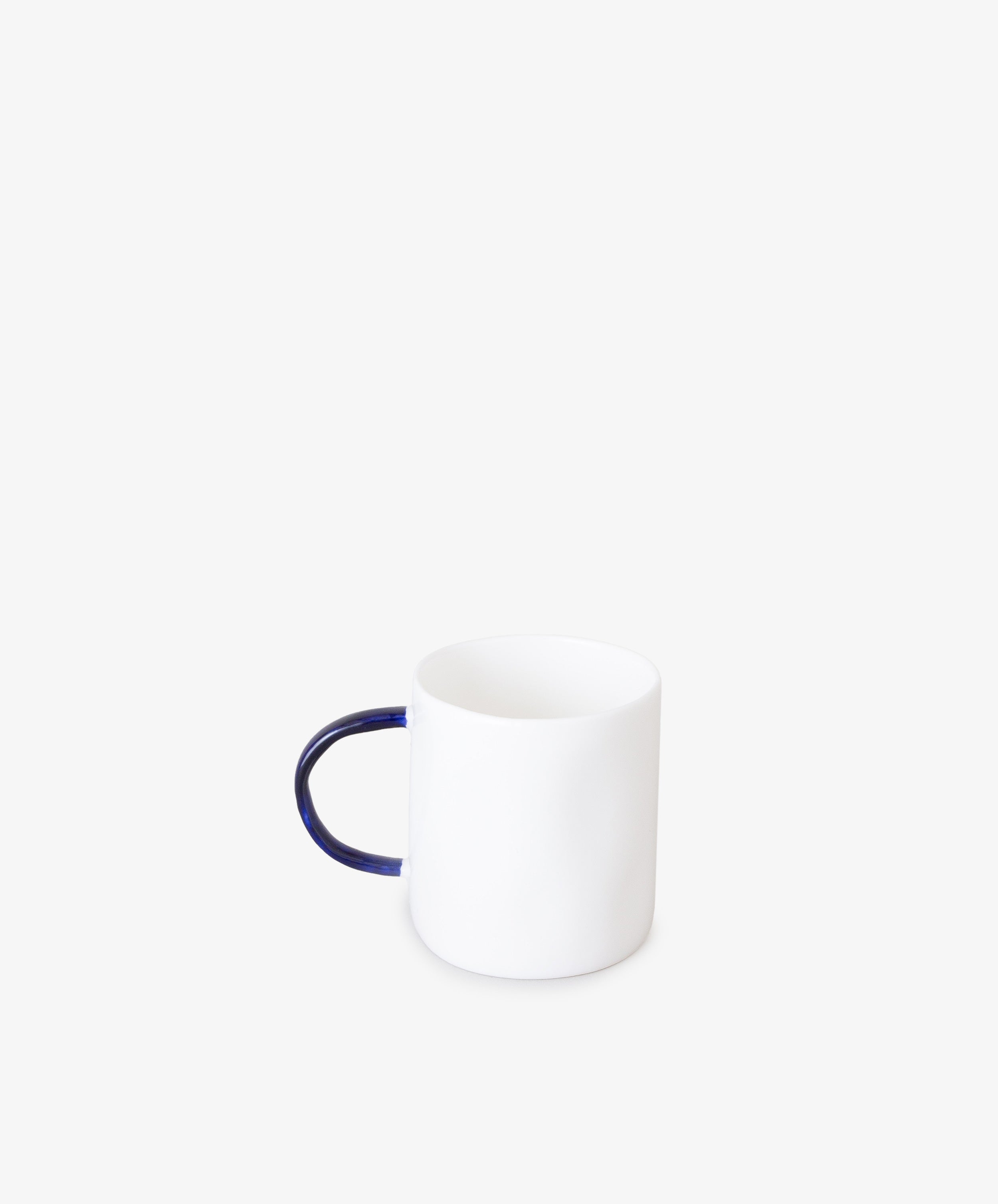 Espresso Cups by Feldspar. Small white cylindrical china cup with thin, rounded cobalt blue handle.