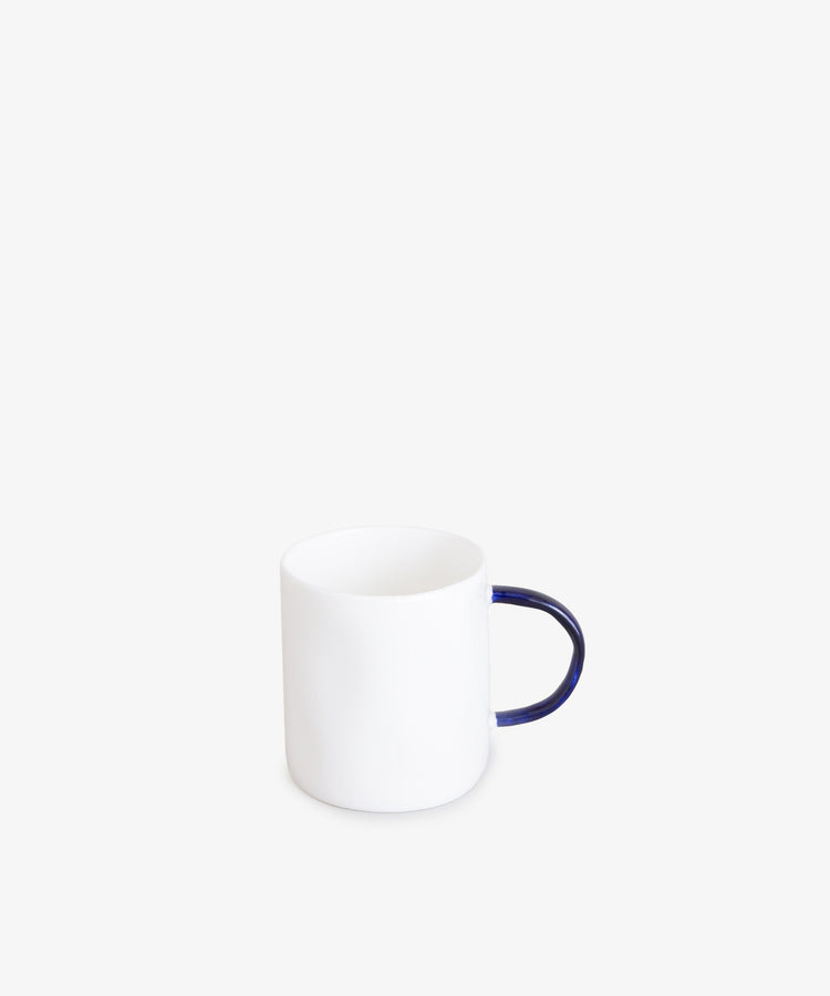 Espresso Cups by Feldspar. Small white cylindrical china cup with thin, rounded cobalt blue handle.