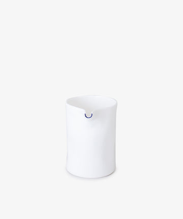 Milk Jug by Feldspar. White china minimalist small jug, painted cobalt blue at tip of spout. Front view.