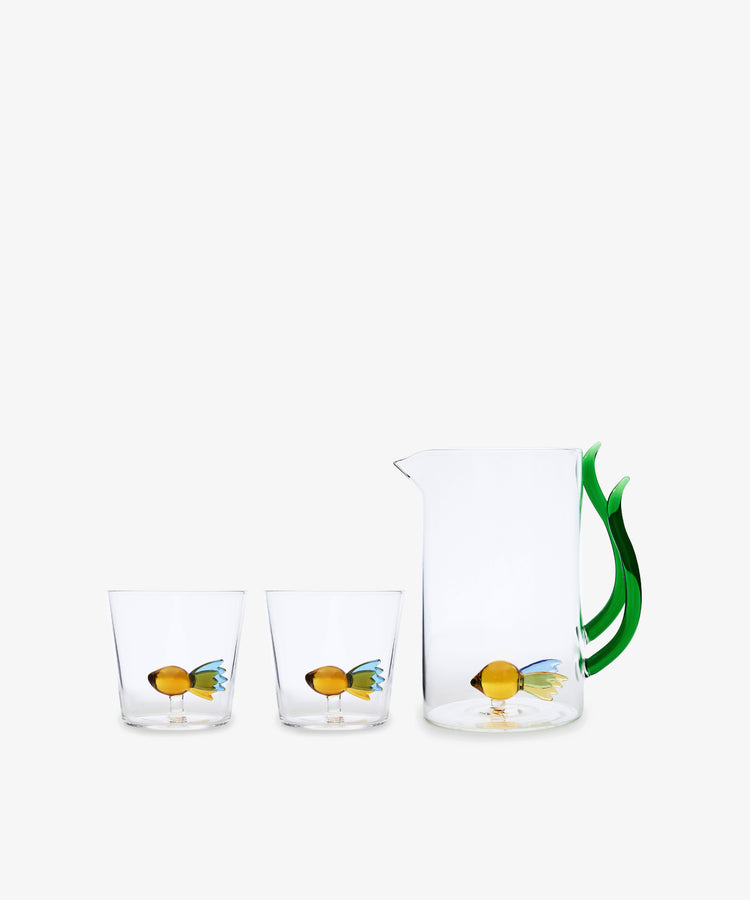 The Fish Pitcher is hand-blown with a green seaweed handle and comes with two matching glasses, each showcasing a vibrant fish design inside.