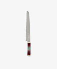 The Bread Knife features a long, serrated blade ideal for slicing through even the toughest crusts. Its handle displays horizontal stripes in red, black, and white, and the knife is set against a plain white background.