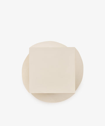 A round white Spiral Notepad, topped with a single square white Spiral Notepad, both set against a plain white background, creates a layered look reminiscent of a unique paper design.