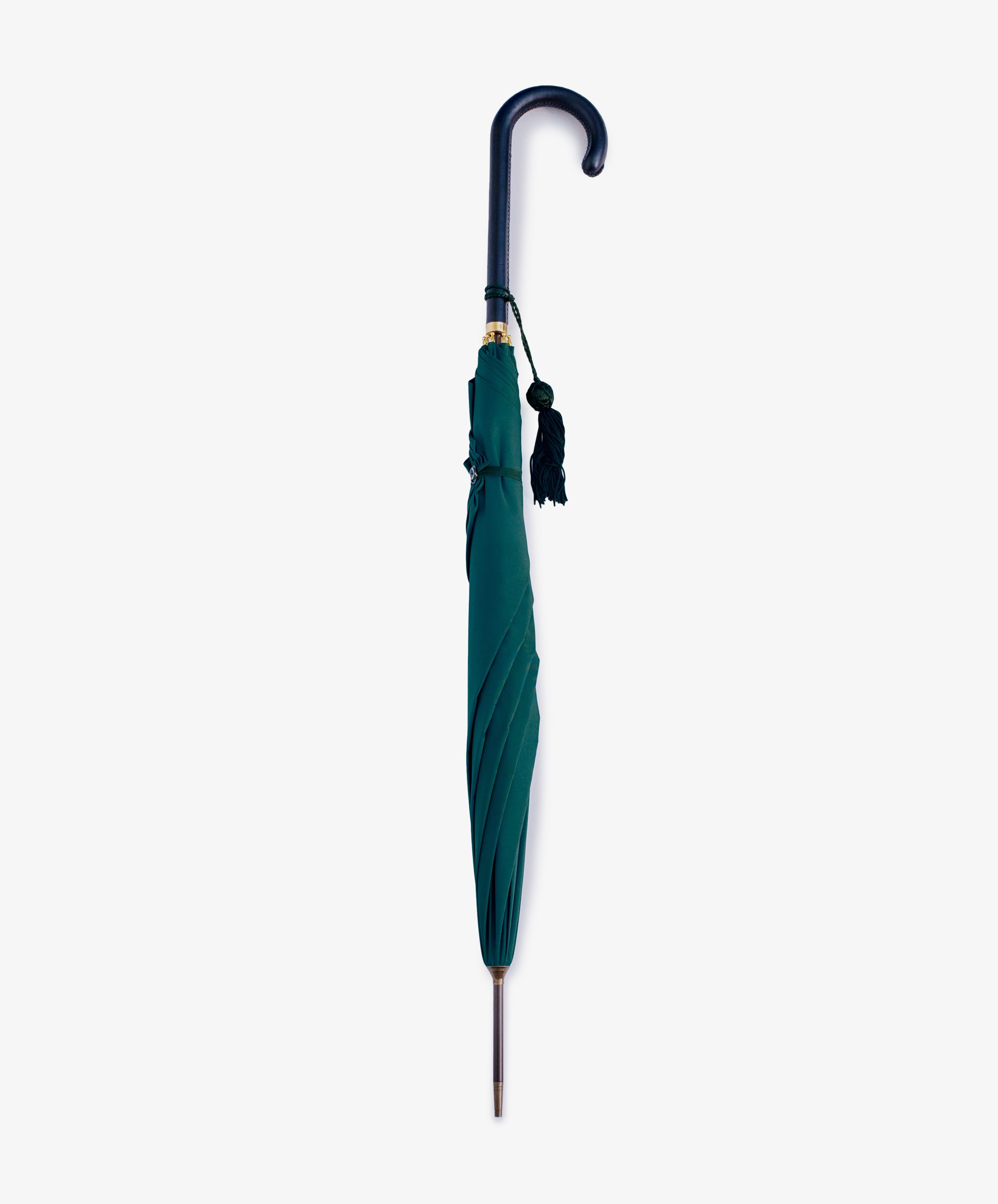 The Victoria Ladies Umbrella is shown closed, featuring a green canopy, a curved dark leather handle with a hanging tassel, and displayed vertically against a plain white background.
