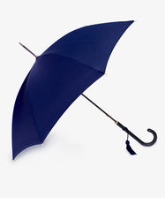 The Victoria Ladies Umbrella features a navy canopy, elegant leather crook handle, and a small tassel, shown open against a white background.