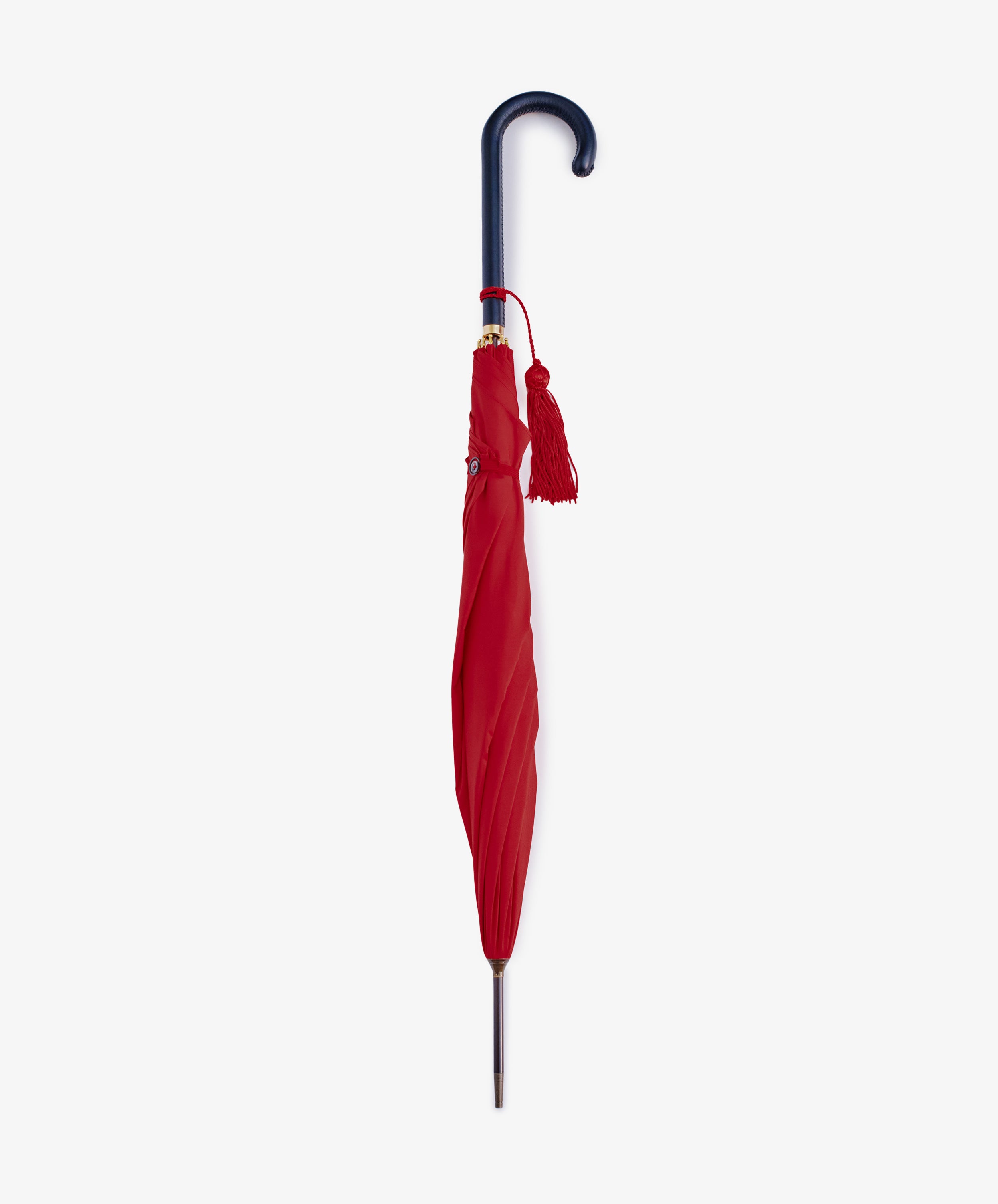 The Victoria Ladies Umbrella, a closed English-style design with a red canopy, curved dark handle, and red tassel, stands upright against a plain white background.