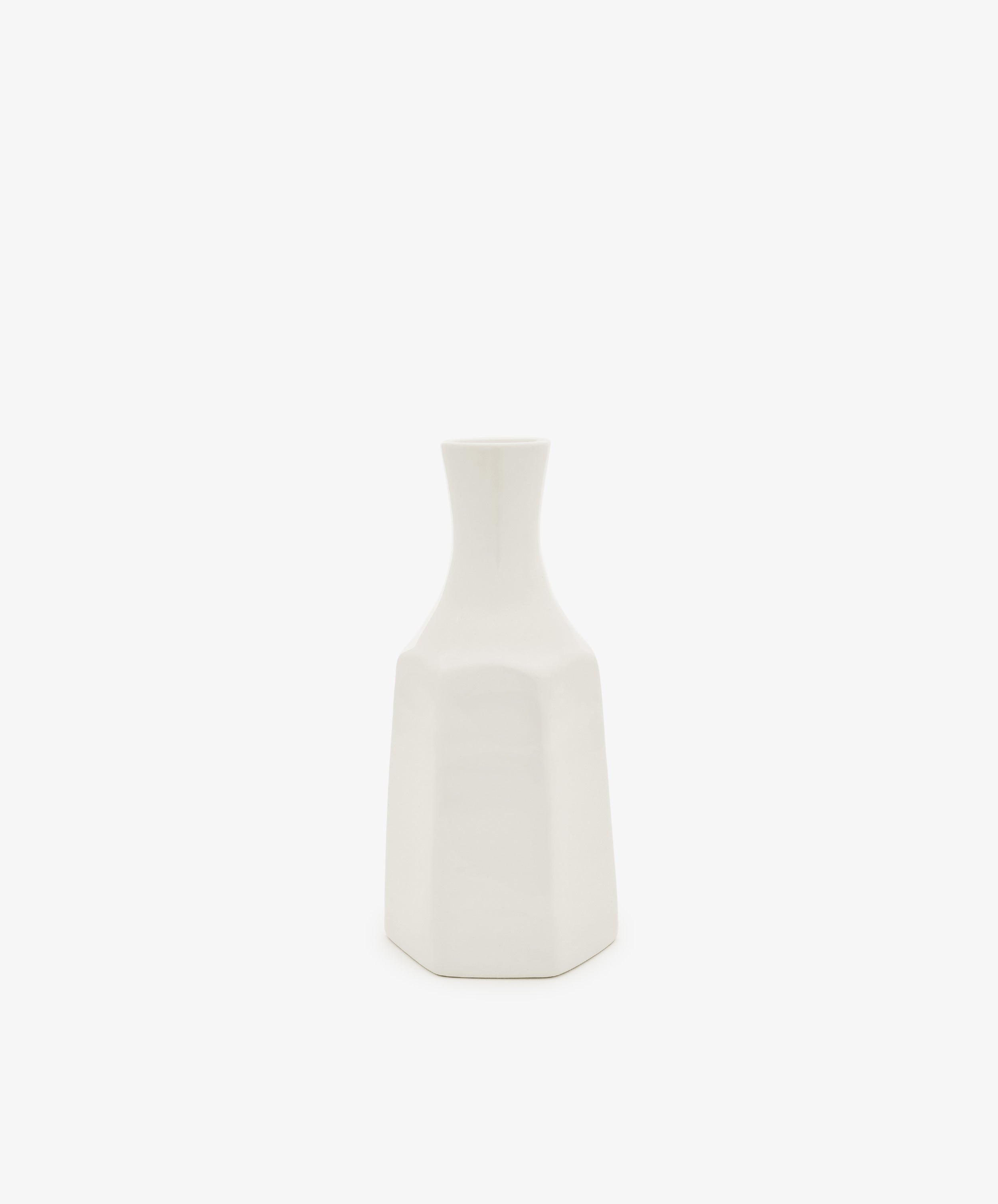 The Cirrus Bud Vase by Frances Palmer is a small, white ceramic piece featuring a geometric design with a narrow neck and hexagonal base, showcased against a plain white background.