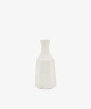 The Cirrus Bud Vase by Frances Palmer is a small, white ceramic piece featuring a geometric design with a narrow neck and hexagonal base, showcased against a plain white background.