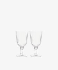The Fresco Goblet, Set of 4 features clear stemmed glassware with vertical ribbed patterns—elegant tableware ideal for festive gatherings and holiday celebrations.