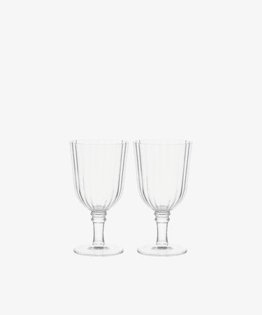 The Fresco Goblet, Set of 4 features clear stemmed glassware with vertical ribbed patterns—elegant tableware ideal for festive gatherings and holiday celebrations.