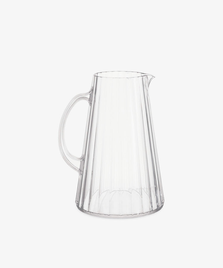 The Fresco Pitcher is a clear, durable pitcher with a handle and spout, featuring vertical ridged lines inspired by Italian café glassware. Shown against a plain white background.