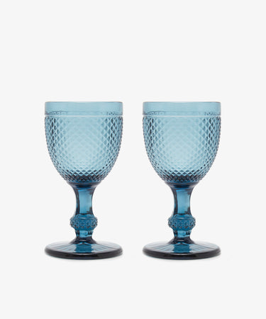 A set of six Celeste Red Wine Glasses, featuring subtle coloring and diamond cut patterns, is arranged side by side on a plain white background.