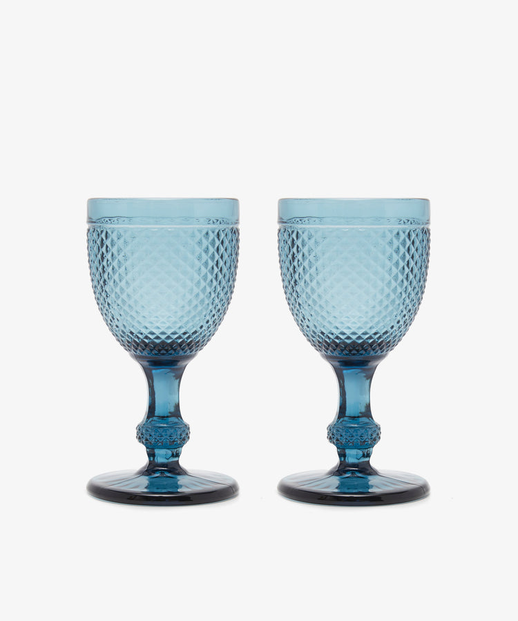 A set of six Celeste Red Wine Glasses, featuring subtle coloring and diamond cut patterns, is arranged side by side on a plain white background.
