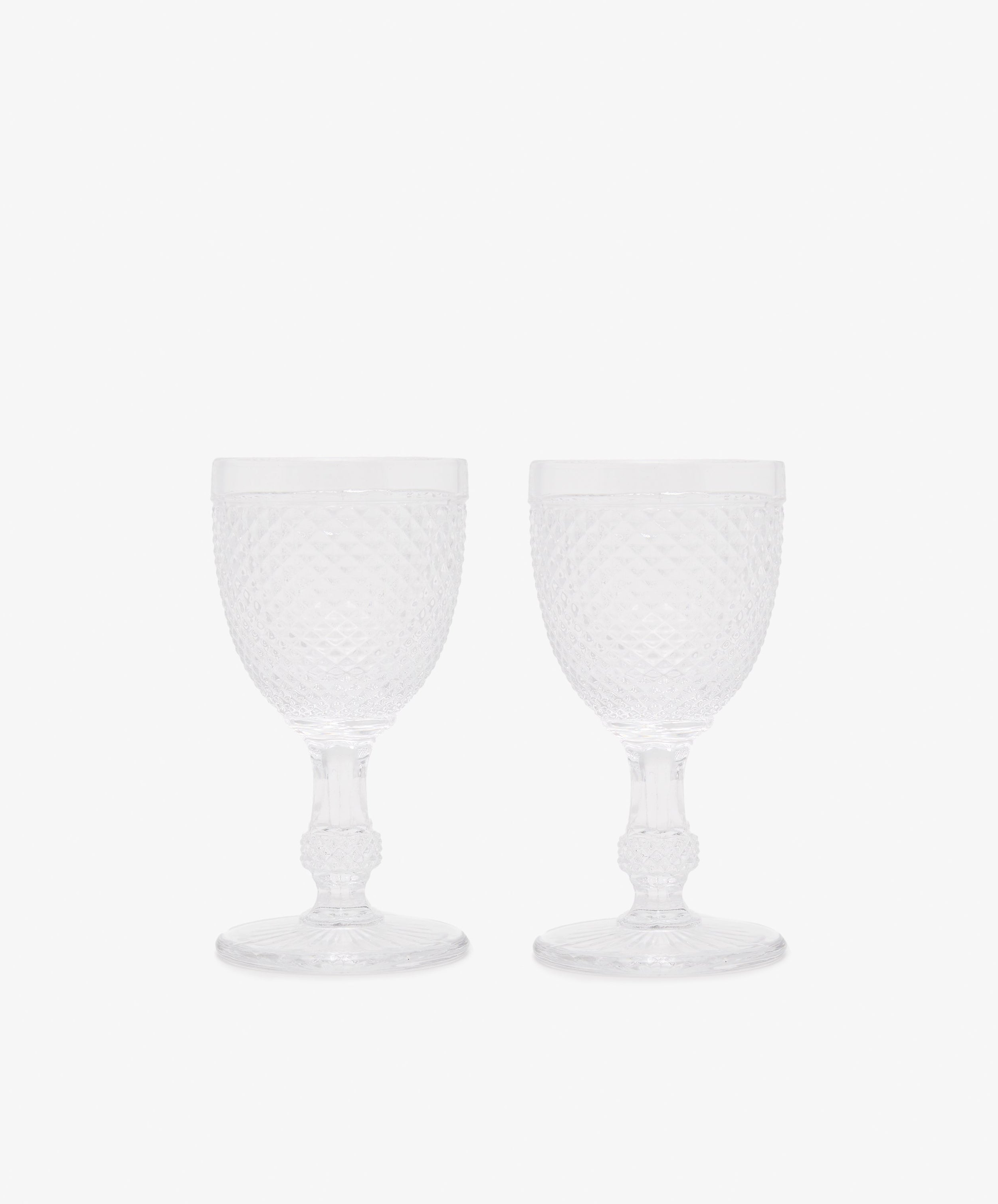 Celeste White Wine Glass. Two transparent stemmed glasses with diamond cut surface.