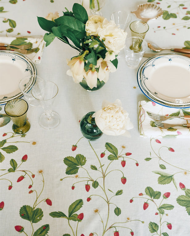 white flowers and dinnerware on floral tablecloth