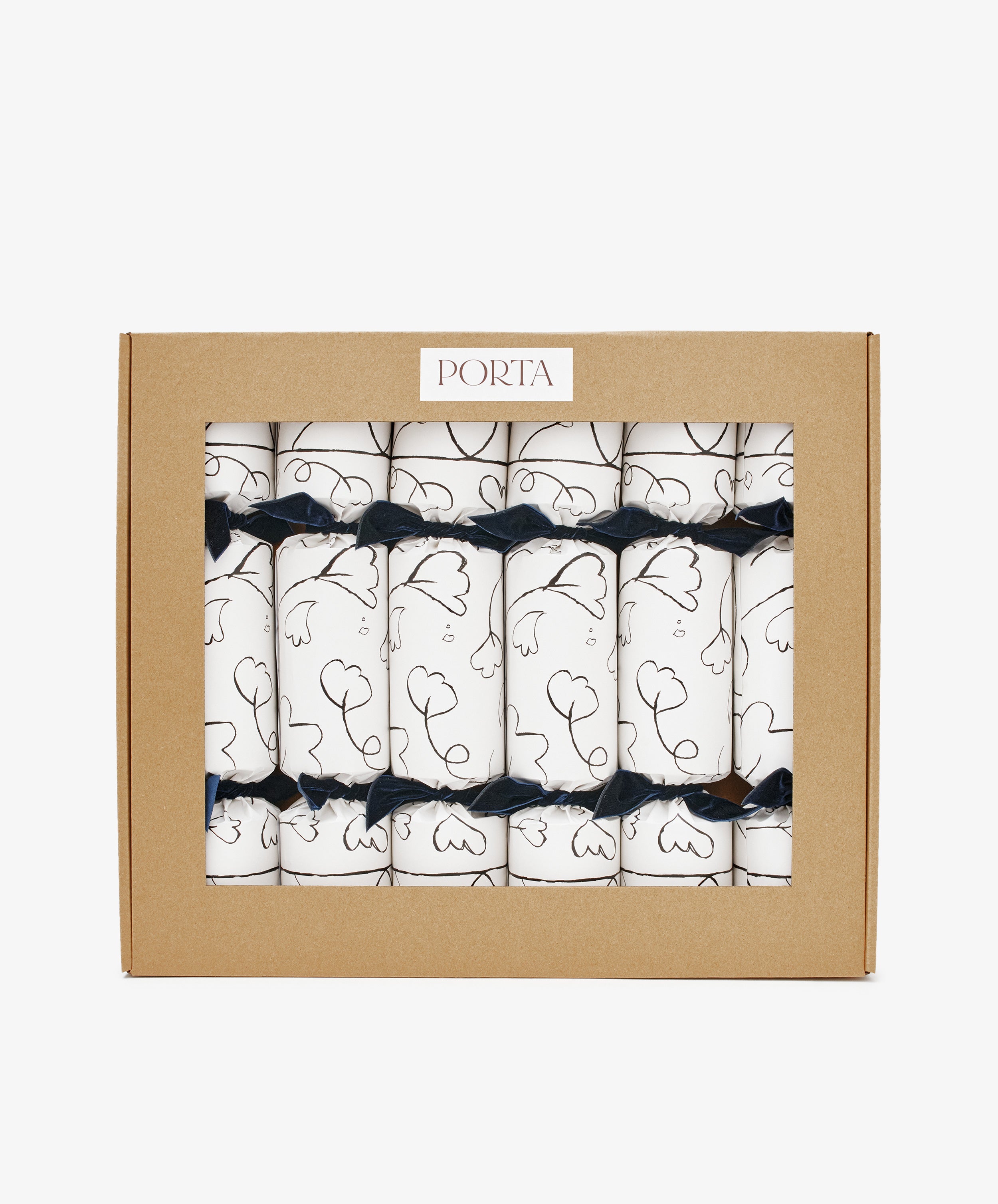 A box of six Capriccio Christmas Crackers featuring white wraps with black line art and navy ribbons, packaged in a labeled brown cardboard window box—ideal festive favors for your holiday party.