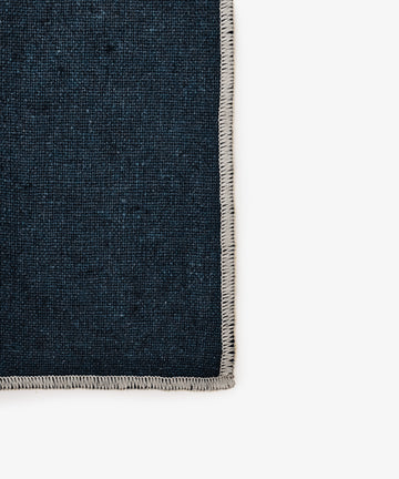Close-up of the Corte Napkin, Set of 6: dark blue, high-quality linen with light-stitched edging on a white background—perfect for eco-friendly placemats and napkins.