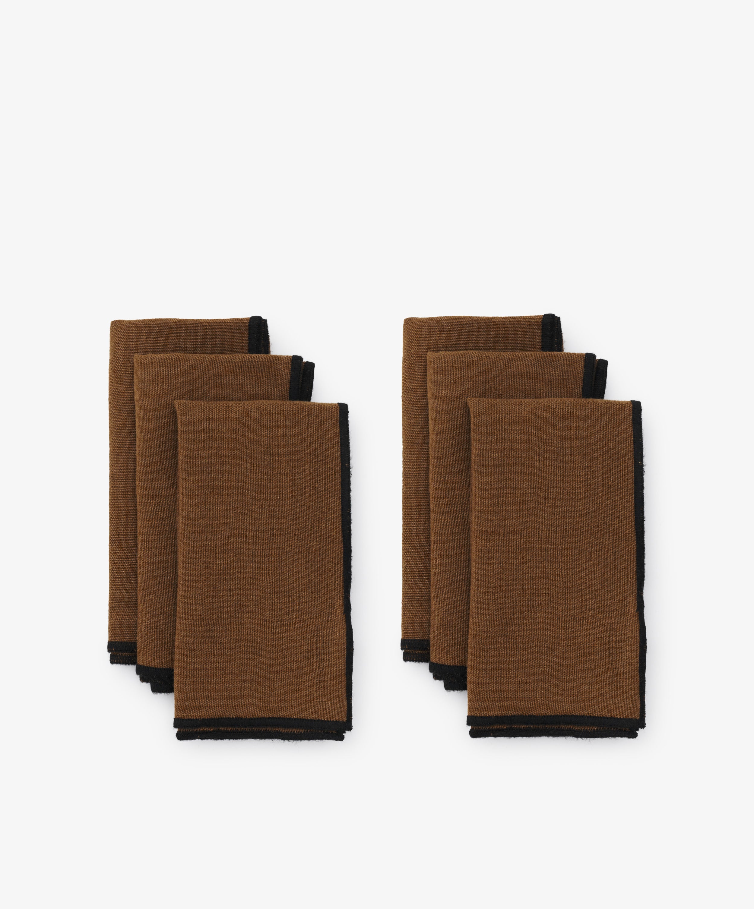 Luri Napkin. Two rows of three napkins in brown linen, with black stitched edges.