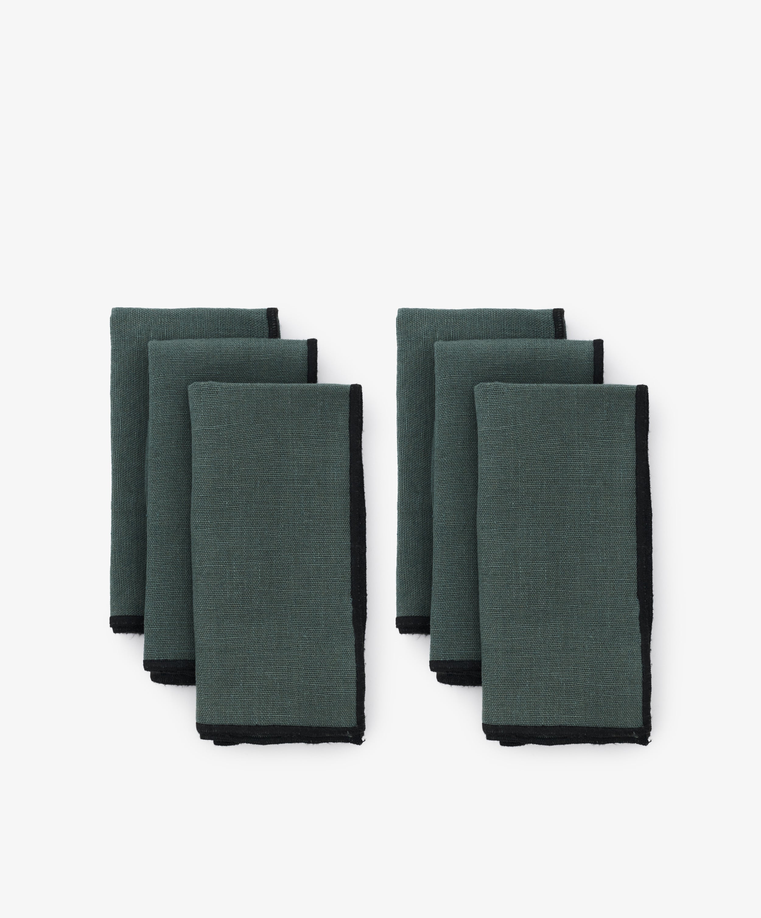 Luri Napkin. Two rows of three napkins in grey-blue linen, with black stitched edges.