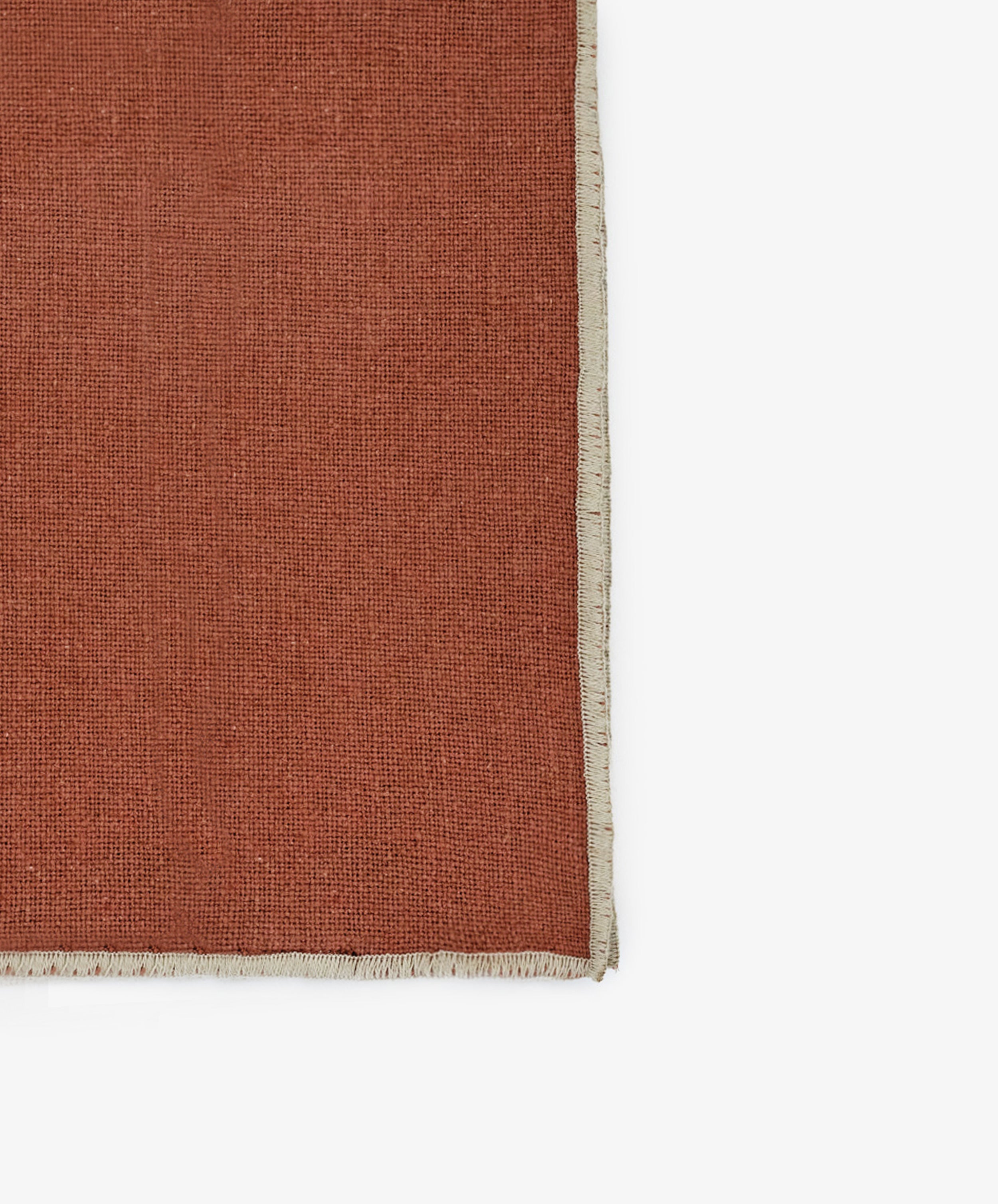 A close-up of the Corte Napkin, Set of 6, in rust linen-cotton blend with a beige fringed border, shown against a white background.