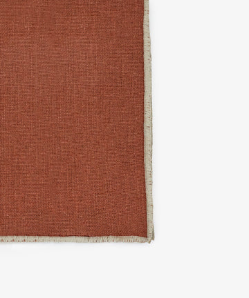 A close-up of the Corte Napkin, Set of 6, in rust linen-cotton blend with a beige fringed border, shown against a white background.