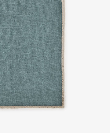 A set of six rectangular Corte napkins in teal linen with beige fringe borders is displayed on a white background, photographed from above. Their rich shades add elegance to any eco-friendly tableware setting.