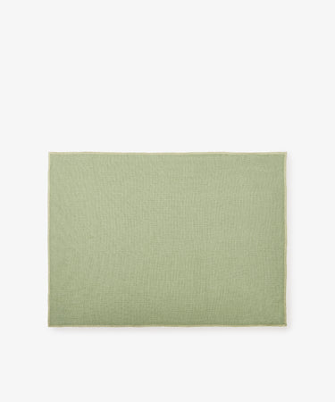 The Corte Placemat, Set of 6, features rectangular, light green mats crafted from high-quality linen and displayed on a plain white background.