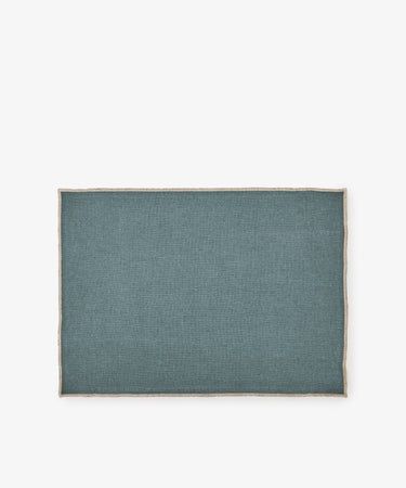 The Corte Placemat, Set of 6, features rectangular eco-friendly teal linen placemats with beige trim, shown on a white background.
