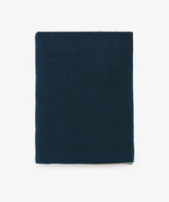 Venise Tablecloth. Folded rectangular dark blue linen cloth with cream stitched hem.