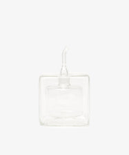 The Cube Oil & Vinegar Cruet features a clear glass, square body and short spout—ideal for any kitchen. Photographed on a plain white background.