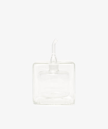 The Cube Oil & Vinegar Cruet features a clear glass, square body and short spout—ideal for any kitchen. Photographed on a plain white background.
