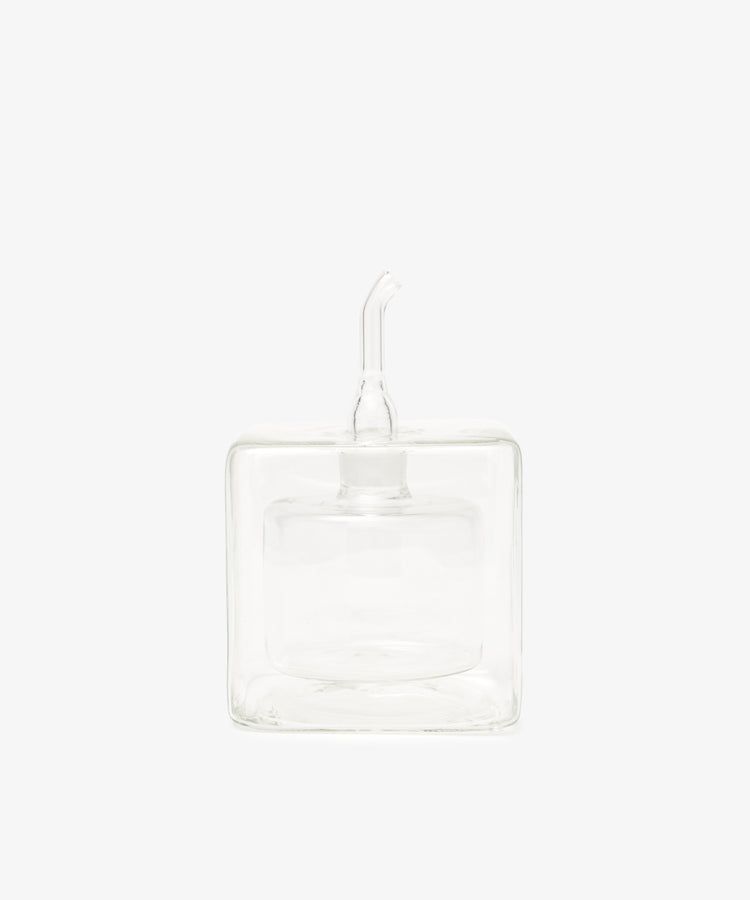 The Cube Oil & Vinegar Cruet features a clear glass, square body and short spout—ideal for any kitchen. Photographed on a plain white background.