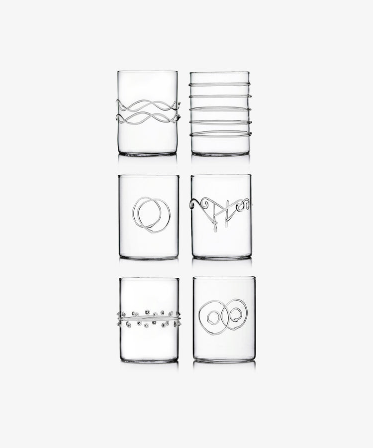 The Deco Shot Glass Set of 6 features clear glasses, each adorned with a unique minimalist silver wire design—arranged in two rows of three—ideal for serving grappa or limoncello with elegance.