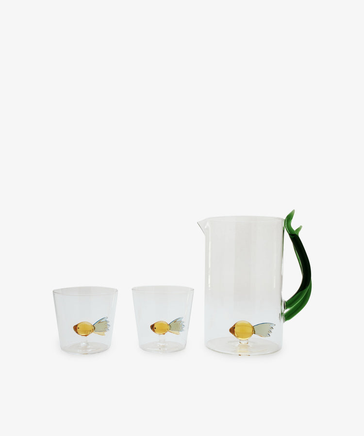 A set of two Fish Tumblers by Ichendorf Milano, crafted from clear borosilicate glass, each adorned with a yellow fish with blue fins—a display of classic craftsmanship.