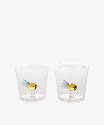 The Fish Tumbler, Set of 2, crafted from borosilicate glass with gold and blue fish designs inside, are displayed side by side on a plain white background.