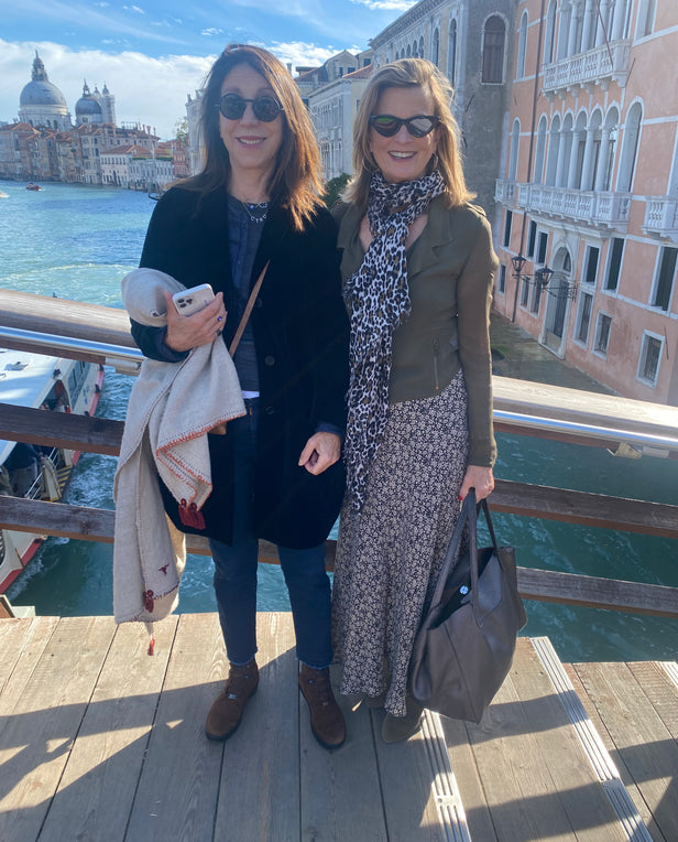 two woman standing on a bridge outside