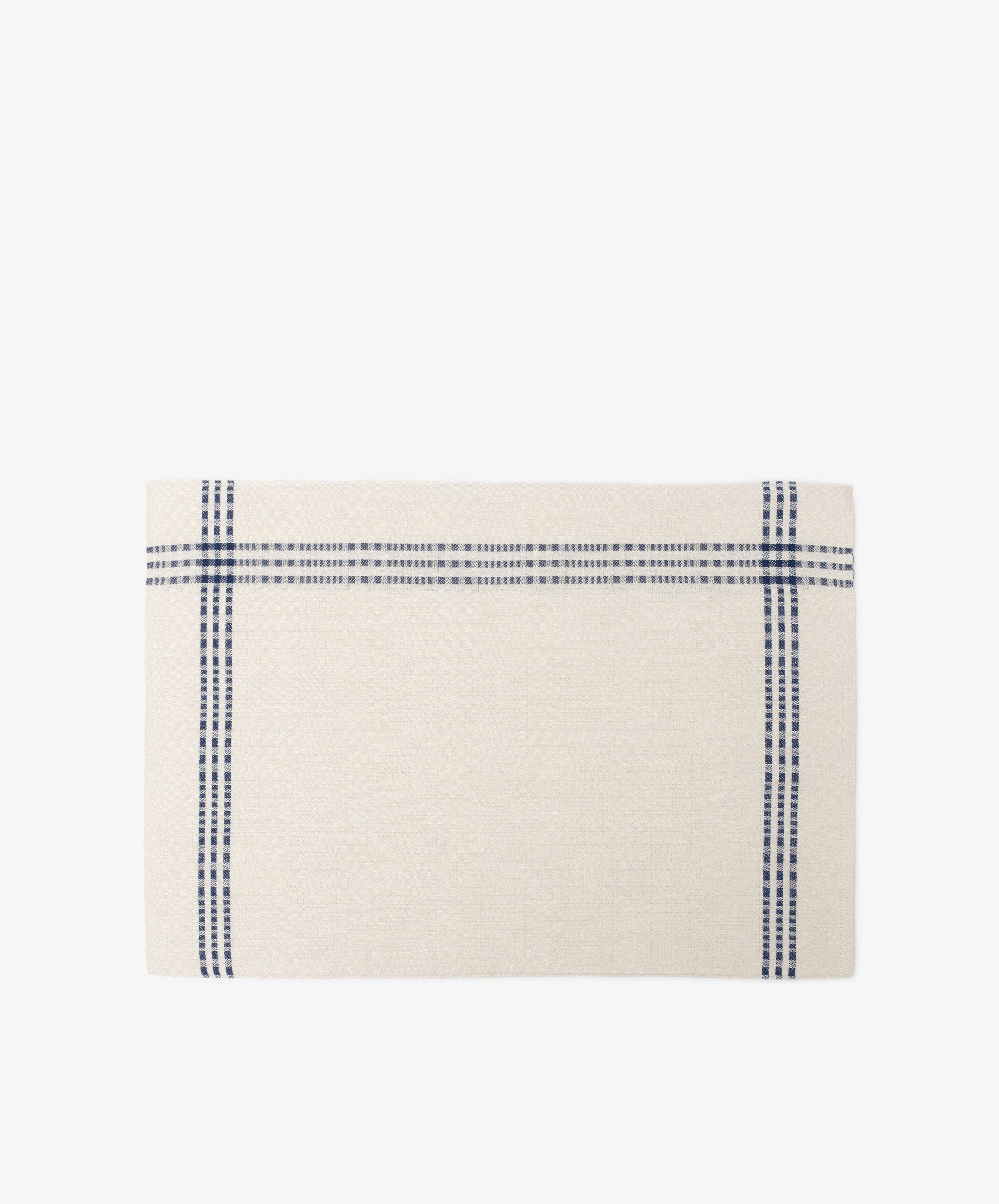 The Tilde Placemat, Set of 6, features a rectangular cream cotton-linen design with two intersecting blue stripes forming a cross near the edges, inspired by the classic Daldräll pattern and displayed on a white background.