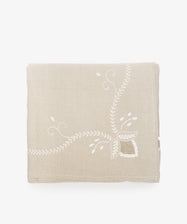 Zelia Tablecloth. Natural linen folded cloth with white embroidery details.