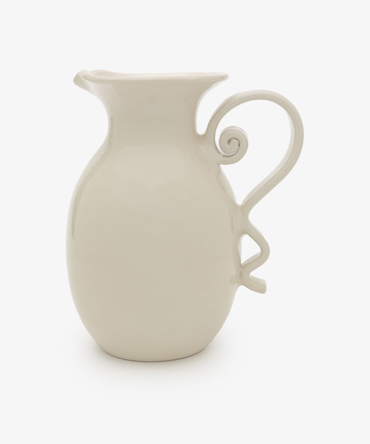 The Ola Vase is a white ceramic piece with a wide spout and decorative curvy handle, showcasing a minimalist silhouette against a plain white background.
