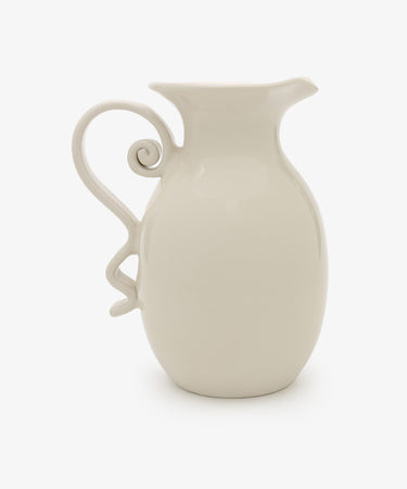 The Ola Vase is a white ceramic piece with a curved, decorative handle and spout, showcasing a minimalist silhouette against a plain white background.