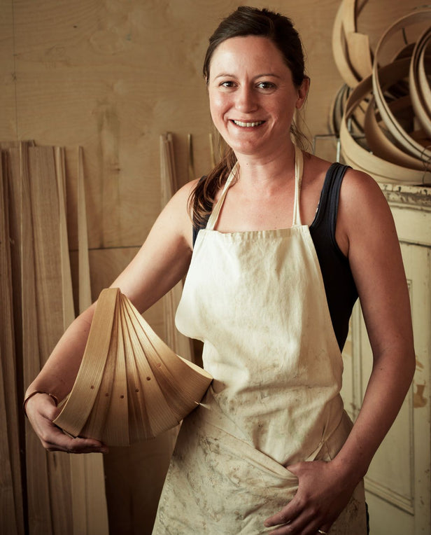 portrait of women artist holding wood basket