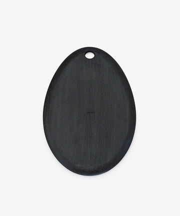 The Alden Egg Board is an oval-shaped black ash board with a small hanging hole, ideal as a wooden serving or cheese board, shown on a white background.