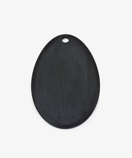 The Alden Egg Board is an oval-shaped black ash serving board with a small hanging hole, perfect as a stylish cheese board, shown on a plain white background.