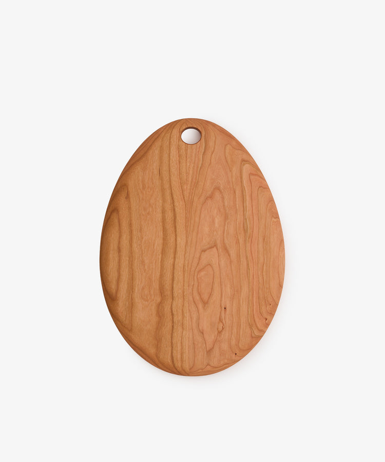 Alden Egg Board—an oval cherry wood cutting board featuring a hole near the top, displayed on a plain white background; perfect as a small cheese board or an elegant wooden serving board.
