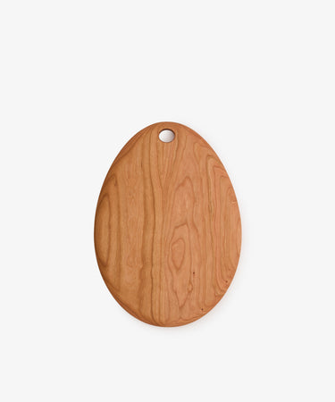 The Alden Egg Board, an oval wooden cheese board with a smooth finish and a convenient hanging hole near the top, is photographed against a plain white background.