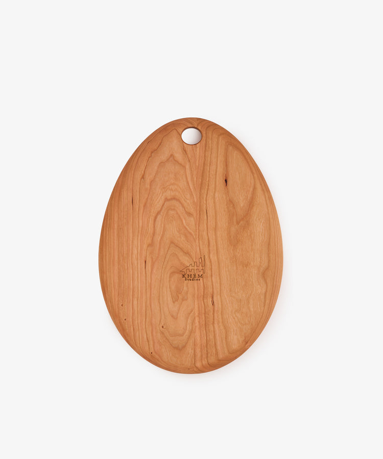 The Alden Egg Board is an oval wooden serving board featuring a small hole near the top for hanging, shown on a plain white background—perfect as a small cheese board for elegant presentations.