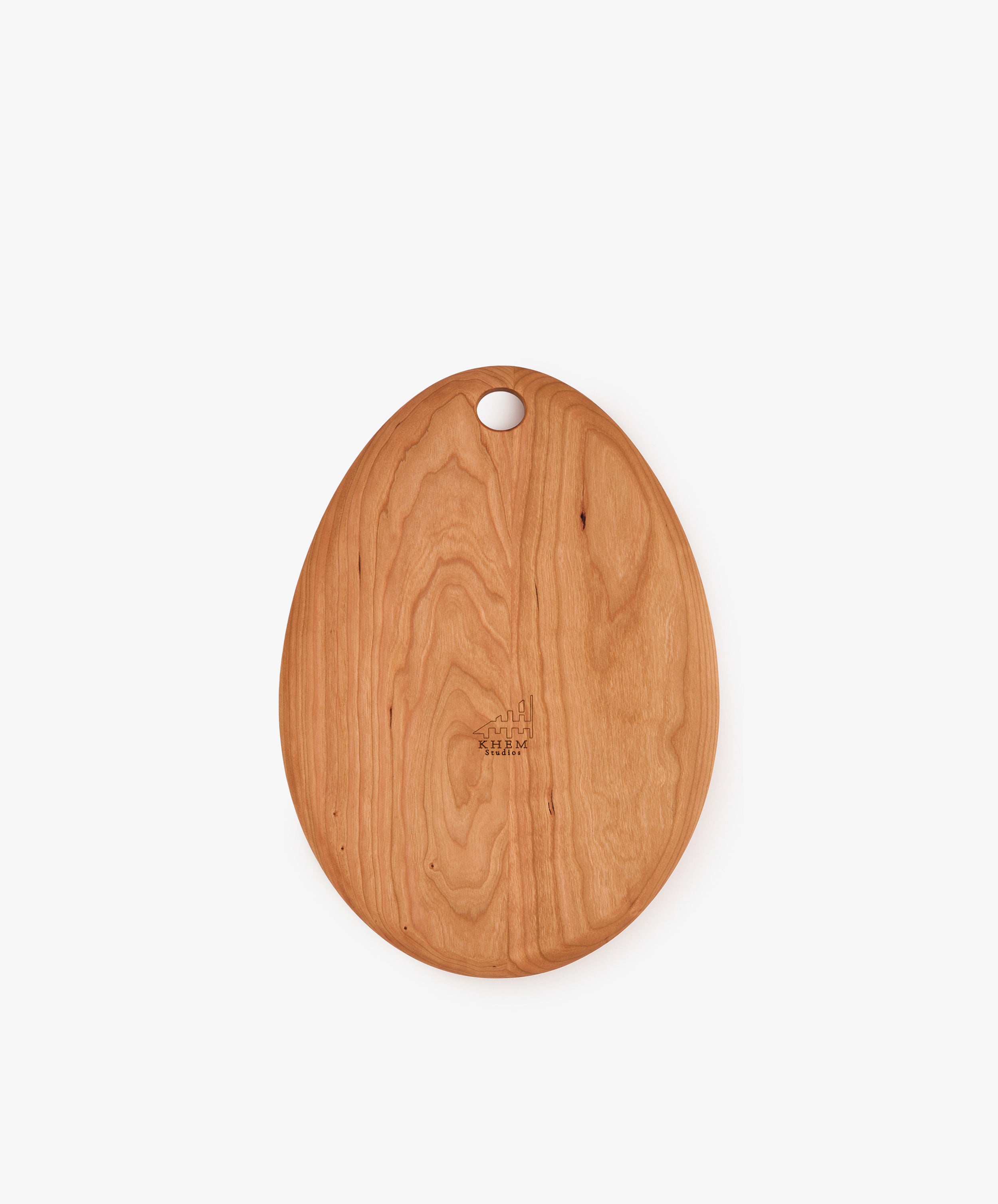 The Alden Egg Board, an oval-shaped cherry cutting board with a smooth finish and a small hole near one end, is photographed against a plain white background.