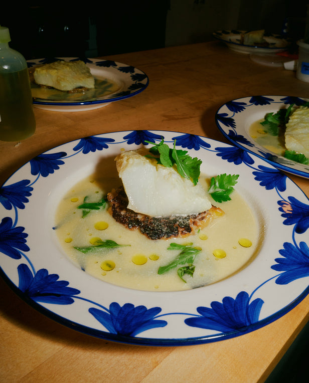 Dish with fish and vegetables on a plate with blue floral pattern